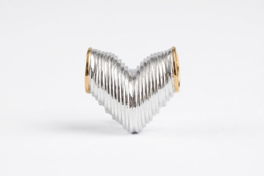 A textured silver heart-shaped ring with polished gold-toned end caps, displayed on a clean white background.